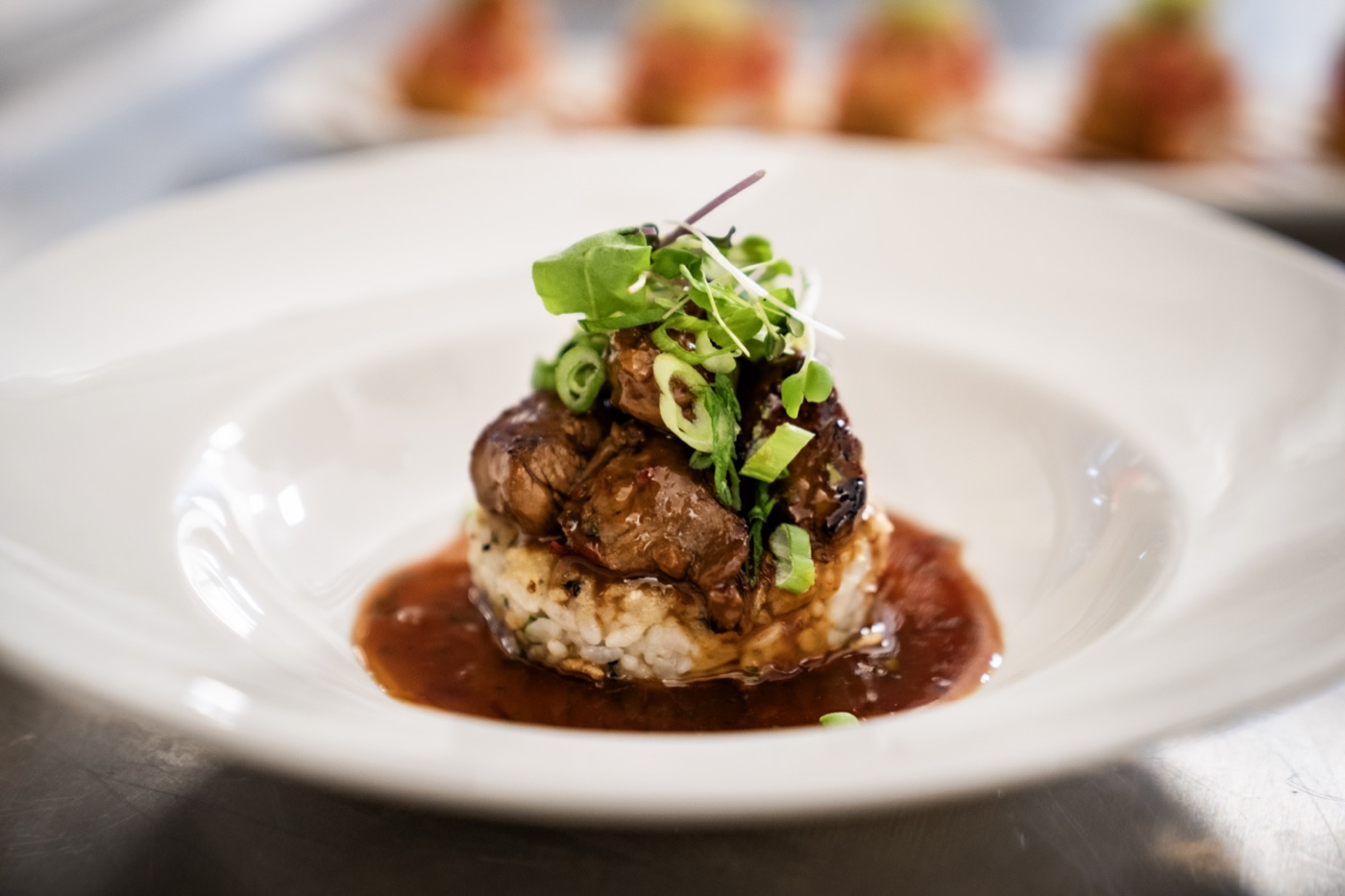 Korean-style filet at Little Alley Steak Alpharetta: seared filet medallions over herbed rice in a savory pan sauce, finished with scallions and micro greens